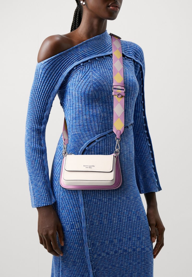 Piccola borsa a mano con schema di colori rosa e bianco, finitura in pelle liscia, dettagli in argento e tracolla regolabile con motivo.