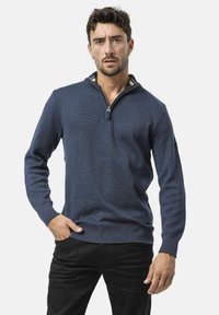 Pull en tricot bleu marine avec un col zippé à moiti�é, tissu texturé, bords côtes aux poignets et à l'ourlet, avec un détail de col intérieur multicolore.