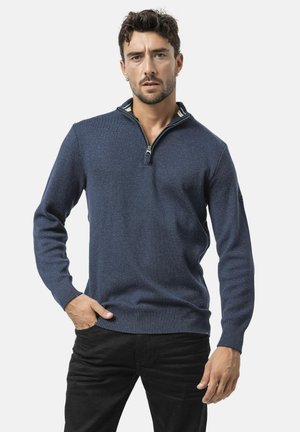 Pull en tricot bleu marine avec un col zippé à moitié, tissu texturé, bords côtes aux poignets et à l'ourlet, avec un détail de col intérieur multicolore.