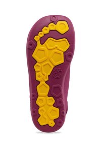 Sole of a shoe featuring a purple rubber base with a yellow hexagonal pattern, designed for grip and traction.