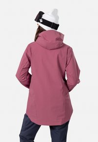 Rosa vattentät jacka med huva, med långa ärmar och rak skärning. Slät textur och minimalistisk design.