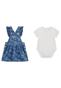 Robe salopette en denim avec des bretelles à volants, motif cœur, et logo "GUESS". Accompagnée d'un body blanc à manches courtes avec un détail de logo.