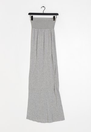Jupe maxi grise en tissu tricot doux et extensible. Elle présente une taille élastique et une silhouette fluide avec de subtils plis.