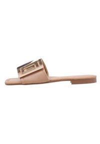Sandalía plana beige hecha de material sintético suave, con una correa ancha y una hebilla decorativa en tono dorado en la parte superior.