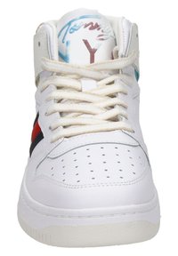 Sneaker alta bianca con punta perforata, lacci beige, strisce laterali rosse e nere e scritte blu-rosse sulla linguetta.