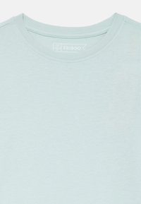 Ljusblå kortärmad t-shirt i mjukt material. Har rund halsringning och en diskret varumärkesetikett nära kragen.