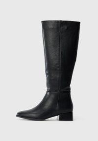 Bottes en cuir noir montantes jusqu'aux genoux, avec un bout pointu et un petit talon bloc. Texture lisse avec un design simple et sans ornements visibles.