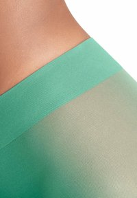 Legginsy z wysokim stanem w gradientowym wzorze, z turkusowym górnym paskiem przechodzącym w stonowaną oliwkową tkaninę o prążkowanej teksturze.