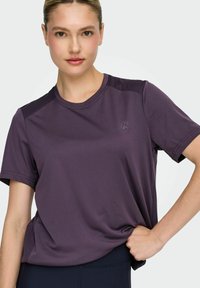 Paars sportshirt met korte mouwen, ronde halslijn, gestructureerde zijpanelen en een klein logo op de borst. Zacht, lichtgewicht stof.