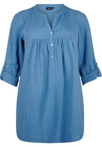 Chemise bleue légère avec un devant plissé, une fermeture par boutons et des manches retroussables. Présente un buste texturé avec de petits détails ajourés.