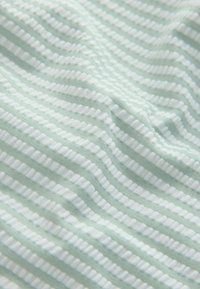 Tela verde claro con rayas blancas alternadas, texturizadas y lisas, con una textura suave de punto y un patrón de ondas suaves.