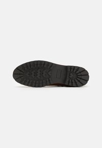 Talpa de cizma din cauciuc negru cu un model texturat, având caneluri și ride în formă de zig-zag pentru aderență. Design elegant și funcțional.
