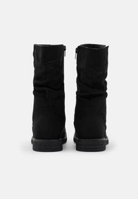 Bottines en daim noir avec un design plissé, des fermetures éclair latérales et des semelles en caoutchouc texturé. Silhouette simple et épurée avec un minimum de détails.