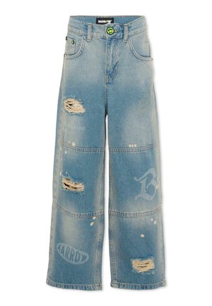 Jasnoniebieskie dżinsy o szerokich nogawkach z przetarciami, przeszyciami paneli, wyblakłymi białymi nadrukami logo oraz zapięciem na zielony guzik z uśmiechniętą buźką.