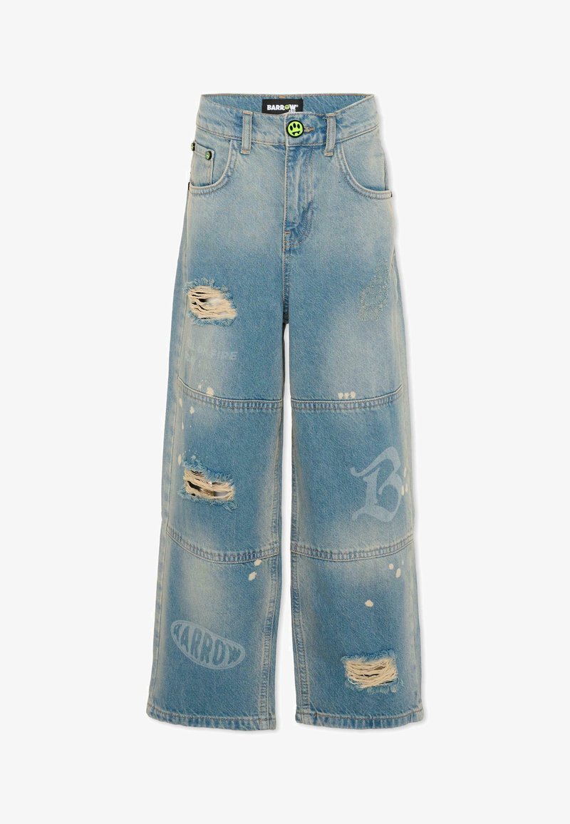 Jean en denim bleu clair à jambes larges avec des effets usés, des détails en panneaux cousus, des logos imprimés blancs délavés et une fermeture à bouton avec un visage souriant vert.
