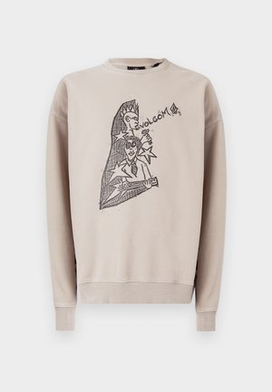 Bež bombažna majica z okroglim izrezom. Na sprednji strani črn grafični motiv z besedilom "Volcom" in abstraktnimi liki.