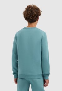 Lichtblauwe sweatshirt met lange mouwen, ribgebreide manchetten en zoom. Glad textuur, ronde halslijn, met een ontspannen pasvorm ontwerp.