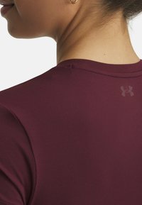 Bordo sportlik särk sileda tekstuuriga, ümar kaelus ja lühikesed varrukad. Seljal on tagasihoidlik logo.