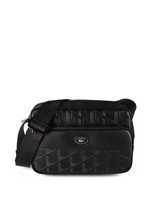 Bolso bandolera negro Lacoste con patrón geométrico en relieve, correa ajustable y bolsillo frontal con cremallera con el logo del cocodrilo de Lacoste.