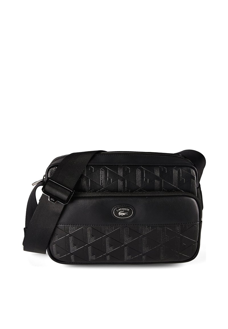 Black Lacoste crossbody bag with embossed geometric pattern, adjustable strap, and front zip pocket featuring the Lacoste crocodile logo.