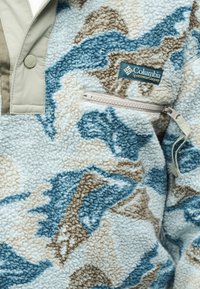 Ζακέτα από φλις Columbia με καμουφλάζ σε μπ λε, μπεζ και λευκό χρώμα, τσέπη με φερμουάρ στο στήθος και υφασμάτινο λογότυπο.