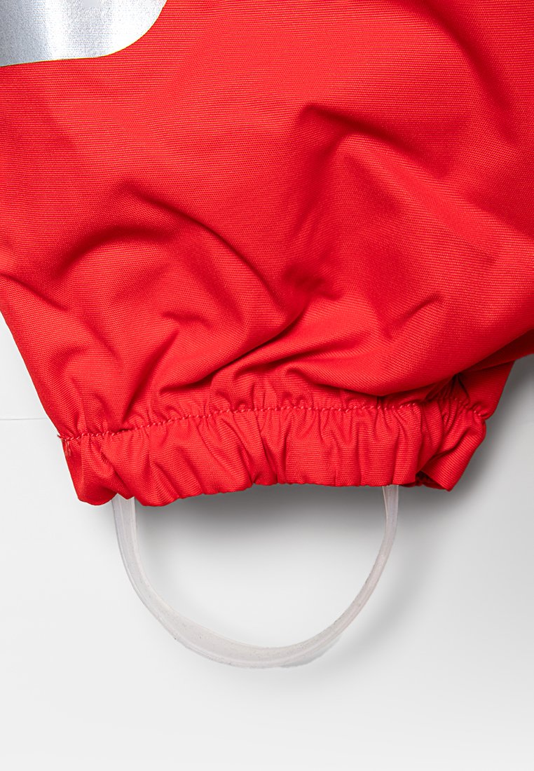 Roter Stoff mit strukturiertem Finish, mit einem gerafften Saum und einer klaren elastischen Schlaufe an der Unterseite, die zur Sicherung eines Gegenstandes gedacht ist.