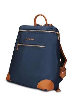 Sac à dos bleu marine avec des accents en cuir fauve, deux poches zippées dorées et une poignée supérieure, vue en angle sur fond blanc.