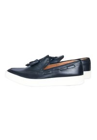 Scarpe slip-on in pelle blu navy con suola in gomma bianca, caratterizzate da un dettaglio decorativo a fiocco e cuciture decorative sulla parte superiore.