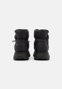 Black padded ankle boots with a textured surface, featuring a high top, pull tab, and a rugged black sole. Adjustable laces at the back.