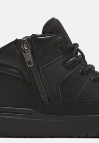 Czarne sneakersy w średnim kroku, wykonane z materiałów skórzanych i tekstylnych, z bocznym zamkiem, sznurowaniem i teksturowymi akcentami. Gumowa podeszwa o minimalnym bieżniku.