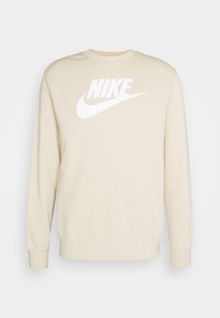 Beige sweatshirt i bomull, med en stor vit "Nike"-logotyp och böjd swoosh. Långa ärmar och ribbad halsringning och ärmslut.