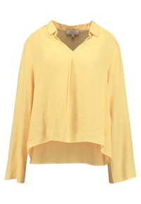 Blouse jaune à manches longues avec un col en V et un col lâche, présentant un ourlet asymétrique et un tissu doux et léger.