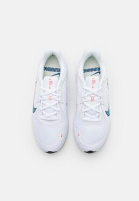 Zapatillas de running blancas con parte superior de malla, swoosh de Nike en color teal, acentos rojos, cordones planos y suela texturizada para tracción. Modelo: Nike Quest 3.