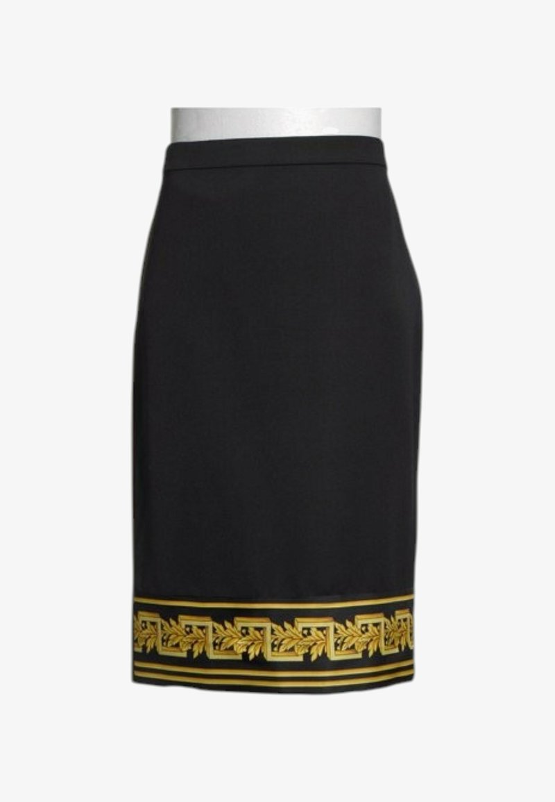 Jupe crayon noire avec un motif géométrique et feuilles dorées en bordure de l'ourlet inférieur.