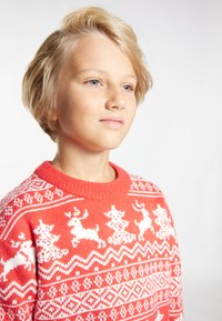 Czerwona sweter z dzianiny z białymi wzorami reniferów i choinek, z ściągaczem przy szyi i teksturowanym splotem.