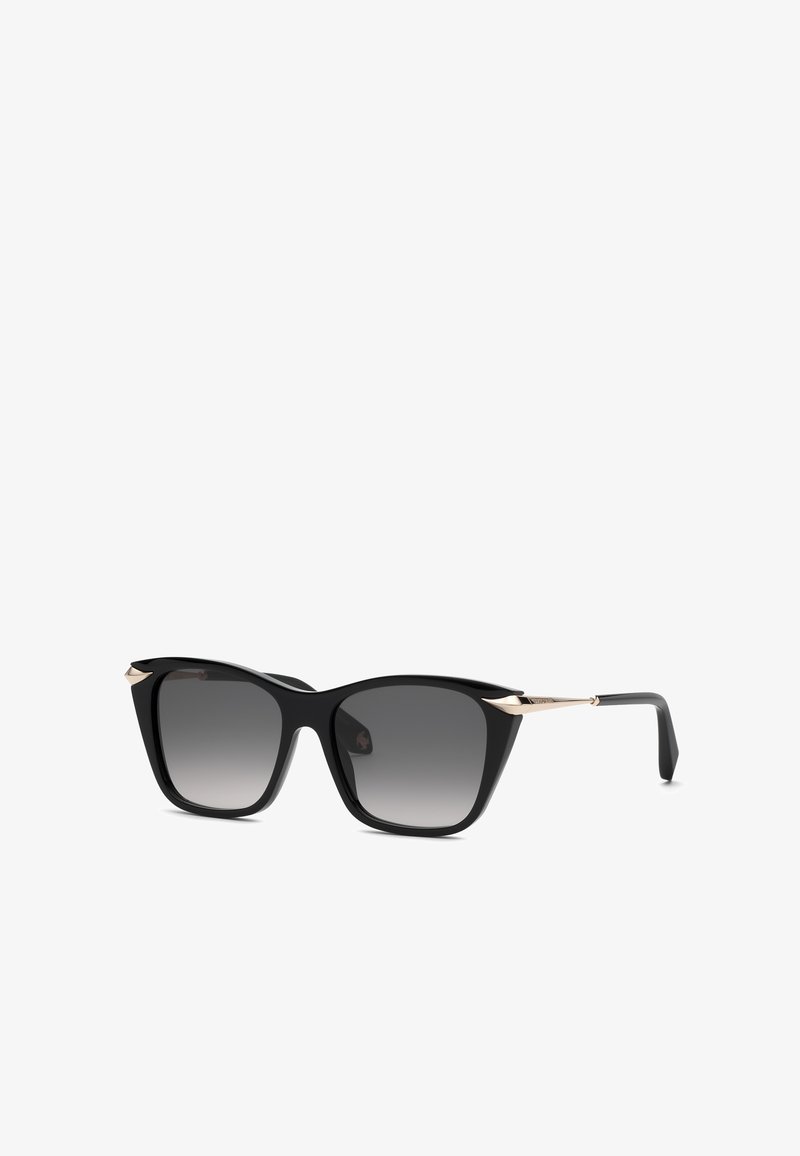 Lunettes de soleil carrées noires avec verres dégradés gris foncé et fines branches dorées, montrées sous un léger angle sur fond blanc.