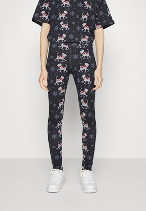 Leggings pretos com um padrão natalino apresentando cães brancos de cachecóis vermelhos e flocos de neve. Feitos de tecido elástico, com um design ajustado.