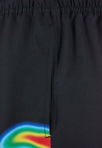 Svarte shorts med elastisk midjebånd, med en fargerik gradientdesign i blått, grønt, gult og rødt langs den ene siden. Glatt tekstur.