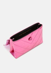 Różowa pikowana torebka kopertowa o błyszczącym wykończeniu, z przekątnymi szwami, okrągłym zapięciem na zatrzask oraz czarnym wnętrzem ze złotym napisem.