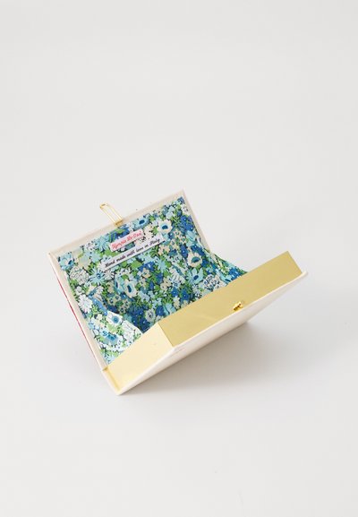 Floral coin purse featuring a blue and green patterned interior, gold hardware, and a cream exterior with a top closure.