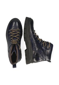Botas de senderismo de cuero azul oscuro con acabado texturizado, cordones marrones, ojales de metal y suela resistente de goma negra.