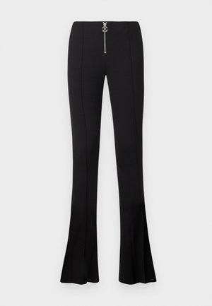 Black flared pants made of stretch fabric, featuring a high waist and a silver zip closure at the front with an embellishment.