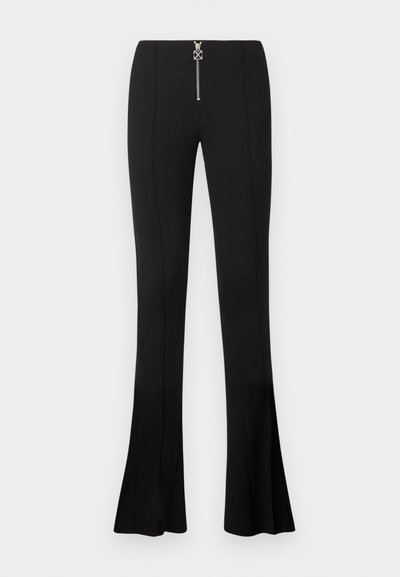 Pantalon noir évasé en tissu stretch, avec une taille haute et une fermeture à glissière argentée à l'avant ornée d'une décoration.