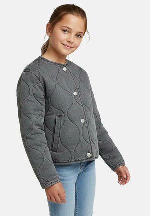 Gewatteerd grijs jack met golvende textuur, ronde halslijn, knopen aan de voorkant en zijzakken, gecombineerd met lichtblauwe jeans.