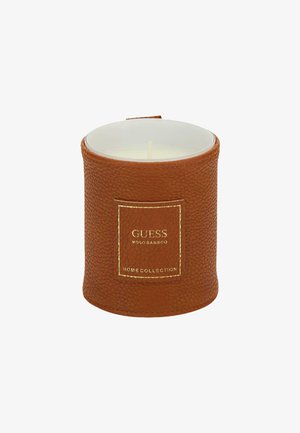 Portacandele texturato marrone con un contenitore interno bianco. Presenta un'etichetta con logo dorato. Forma rotonda con un top liscio e base piatta.