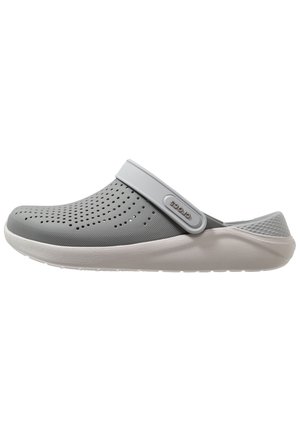 Jasnoszary klapek typu slip-on z otworami wentylacyjnymi, regulowanym paskiem na pięcie oraz białą amortyzowaną podeszwą, idealny do codziennego noszenia.