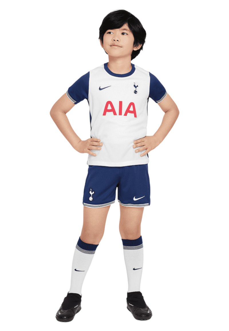 Młodzieżowy zestaw piłkarski Tottenhamu Hotspur składający się z białej koszulki z niebieskimi akcentami, logo "AIA", granatowych spodenek oraz białych skarpet z niebieskimi paskami.