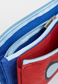 Portafoglio in tessuto blu e rosso con più scomparti con cerniera, dotato di cerniere azzurro chiaro e un design stampato nella sezione rossa.