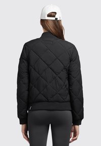Čierna prešívaná bomber bunda s rebrovanými manžetami a spodným lemom. Disponuje okrúhlym výstrihom a hladkým textilným povrchom, ktorý zvyšuje teplo a pohodlie.
