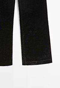 Pantalon noir à jambes larges présenté de la mi-cuisse à l'ourlet sur fond blanc, mettant en valeur la texture du tissu et les détails de couture droite.
